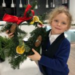 little girl holding home made Christmas wreath