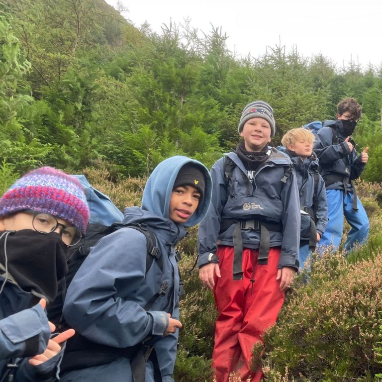 students in their hiking gear showing their thumbs up