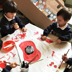 children working on a larger poppy painting