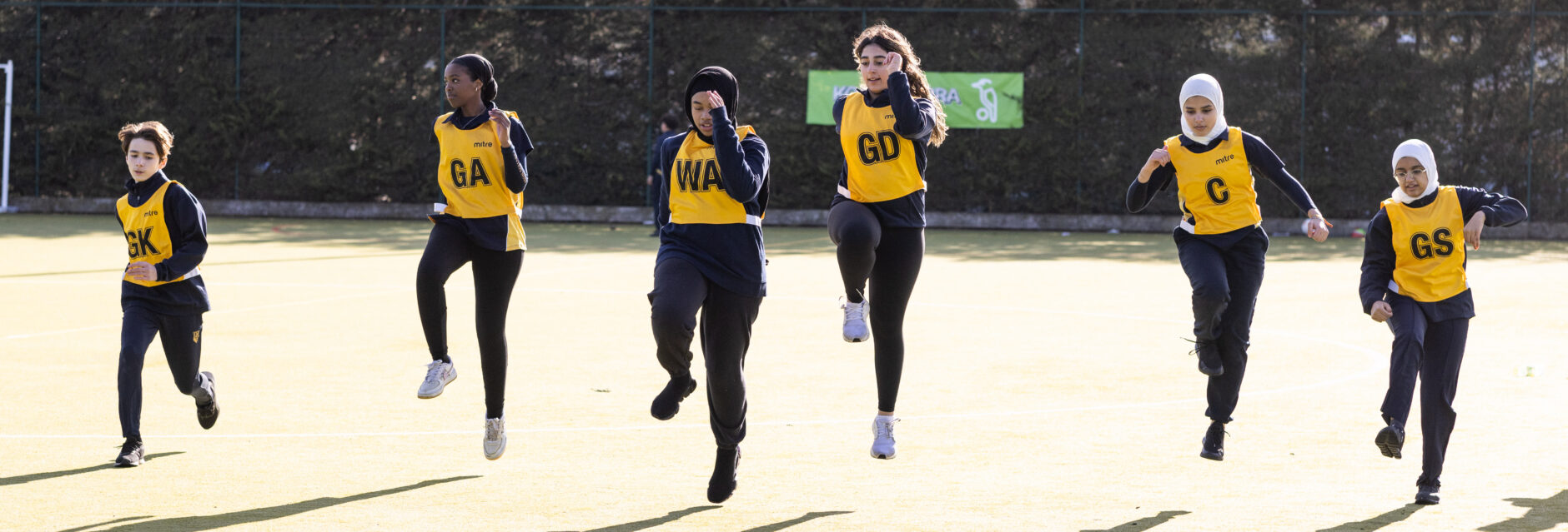 students from the Netball team running along the court
