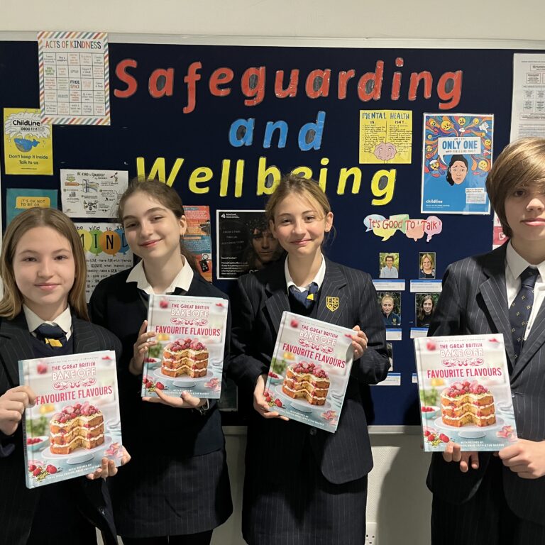 students holding up a cake recipe book